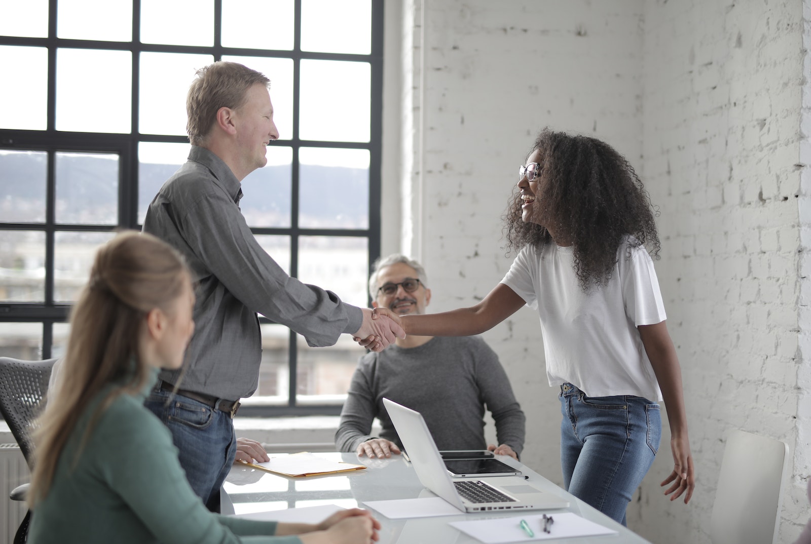 Colleagues shaking hands during teamwork in office