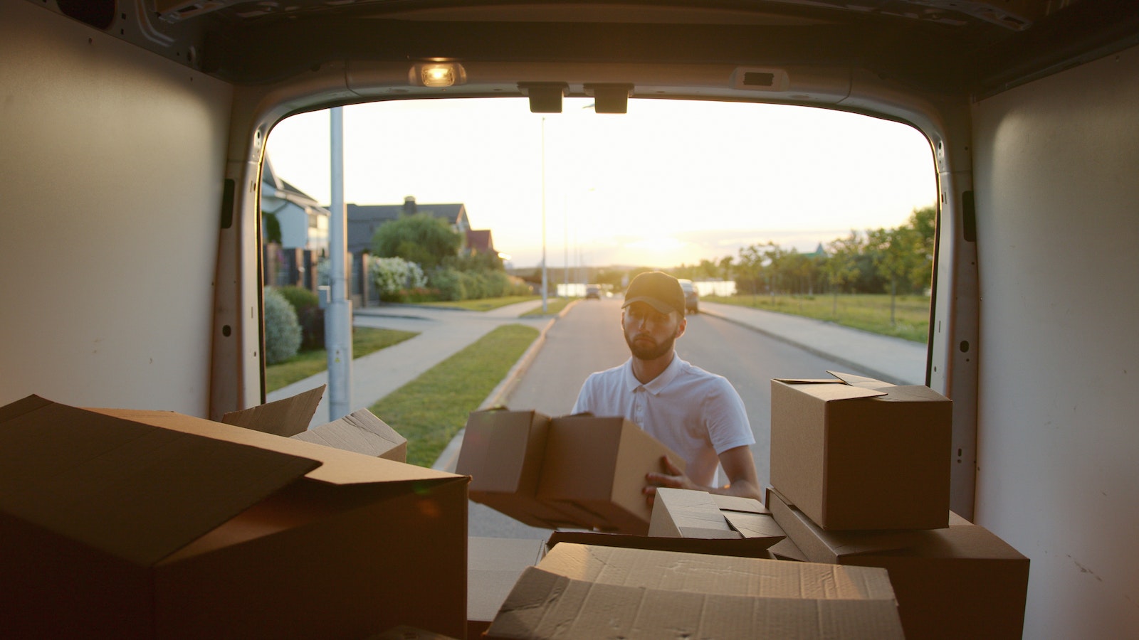 Homme mettant des cartons dans un camion