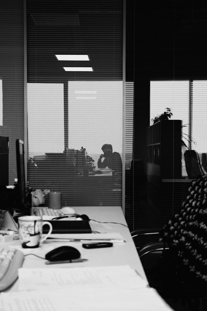 a black and white photo of a man sitting at a desk